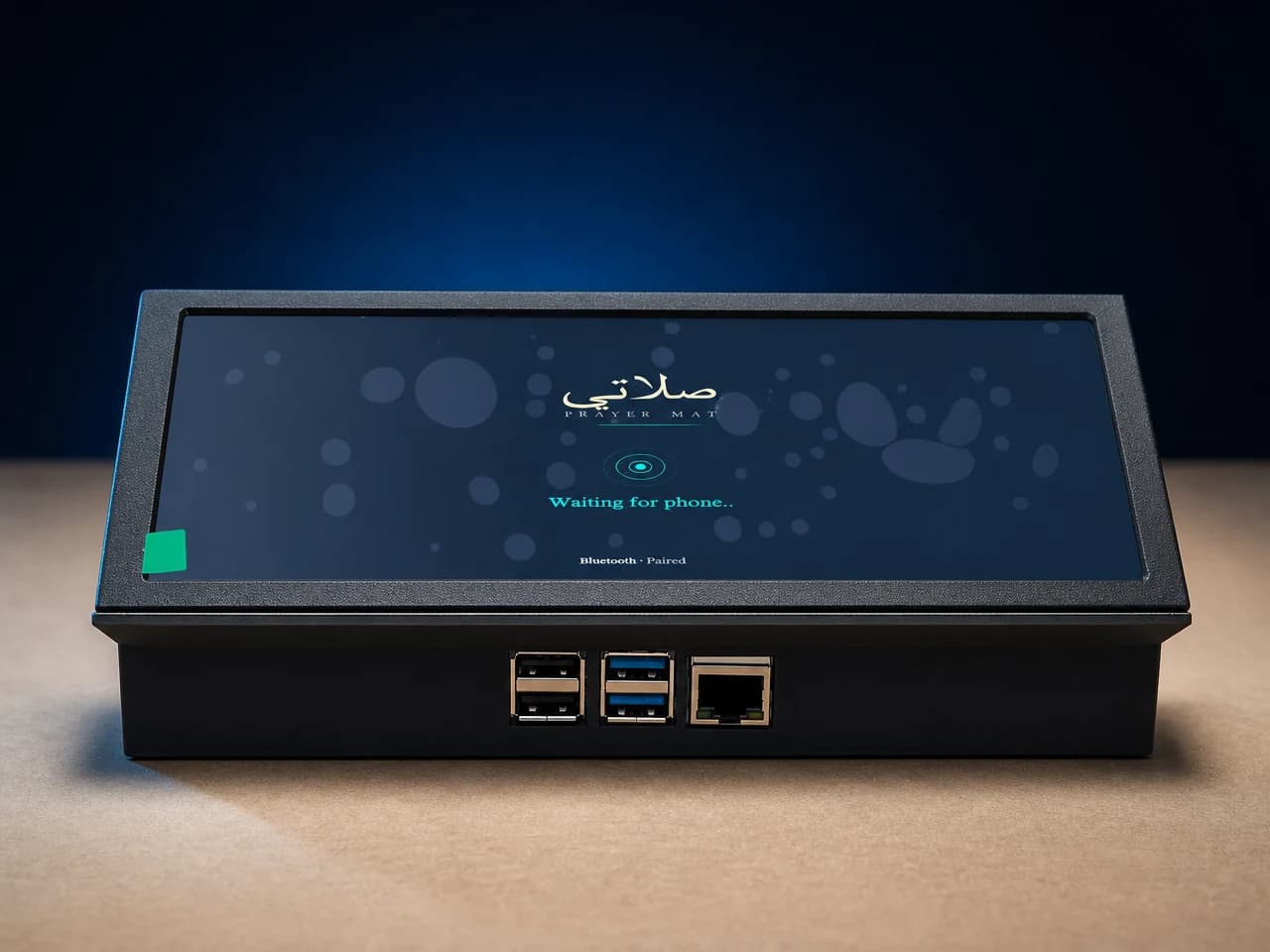The Salati Prayer Mat prototype on a studio surface, its wide display showing the Salati wordmark above a Bluetooth pairing message reading Waiting for phone